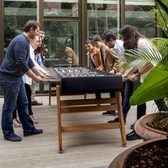 a group of people standing around a table with a chess board on top of it