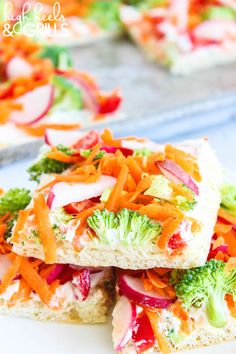 broccoli, carrots and radishes are arranged on bread