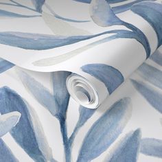 a blue and white wallpaper with watercolor leaves on the paper, which is rolled up