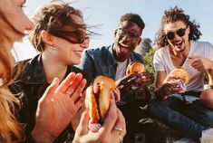 group of young people eating hamburgers together