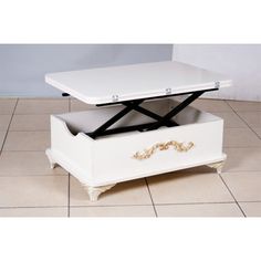 a white coffee table sitting on top of a tiled floor next to a black and white drawer