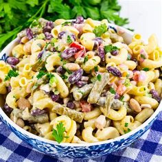 a bowl filled with pasta salad on top of a blue and white checkered table cloth