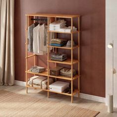 a wooden shelving unit with clothes on it