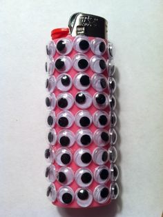 a cell phone case with lots of black and white circles on pink fabric, attached to a wall