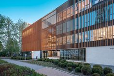 an office building with many windows and trees