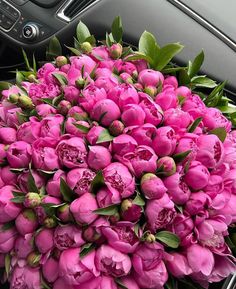 a bouquet of pink flowers sitting in the center of a car