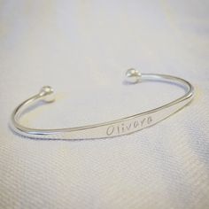 The Silver Tree Sterling Silver Jewellery Silver Childs Bracelet This pretty torque style sterling silver bracelet is the perfect gift for a childs birthday, name day or christening.   Your choice of name is hand stamped across the front, I can engrave approximately 10 characters on the front on the bracelet. The bracelet measures approx 5cm diameter, it is 12cm in length with an opening of about 3cm and can be gently adjusted to fit a baby or child.   Please ensure you type in your choice of name precisely as I cannot accept returns due to inaccuracies. This can be left in a message at checkout Please note that the characters are hand stamped so there may not be perfect alignment like you will find with machine made jewellery giving an artistic finish.  This item is handmade to order. Eac Personalized Sterling Silver Name Bangle, Personalized Sterling Silver Name Bracelet Bangle, White Gold Bracelets With Hallmarks For Gifts, Personalized Sterling Silver Bangle Bracelet, Classic Personalized Birthday Bracelets, Gift Sterling Silver Bracelet, Sterling Silver Bracelets With Hallmarks As A Gift, Custom Name Silver Bangle Bracelet, Silver Custom Name Bangle Bracelet