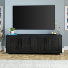 an entertainment center with a large flat screen tv mounted on it's sideboard