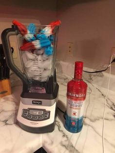 a blender filled with red, white and blue liquid sitting on top of a counter