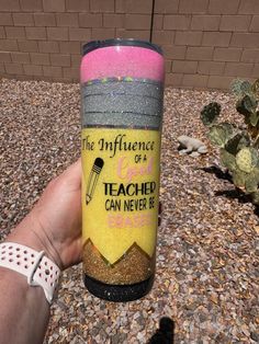 a hand holding a tumble cup that says the influence of a teacher can never be