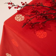 a red table cloth with chinese writing on it and berries in the foreground next to it