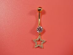 a gold belly ring with a star design on it