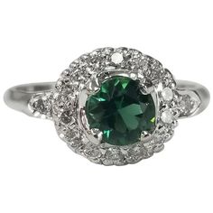 14k white gold tsavorite and diamond halo ring, containing 1 round cut tsavorite weighing .50pts. and 16 round full cut diamonds of very fine quality weighing .25pts. This ring is a size 5.5 but we will size to fit for free. Tsavorite is a trade name for the emerald-green variety of Grossular Garnet that originates in Africa. Tsavorite has become one of the most popular and expensive Garnets, due to its rarity combined with effective marketing tactics. This gemstone was first discovered in Tanza Diamond Halo Ring, Vintage Style Rings, Marketing Tactics, Star Ring, Halo Diamond Ring, Art Deco Diamond, Halo Ring, Halo Rings, Diamond Halo