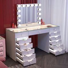 a white vanity with drawers and a mirror on the wall next to a pink couch