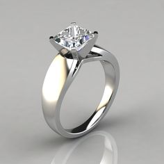 a white gold engagement ring with a single diamond in the center, on a gray background