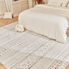 a white bed sitting on top of a wooden floor