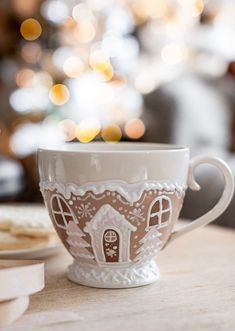 a coffee cup with a gingerbread house on it