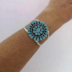 This stunning Squash Blossom bracelet was handcrafted in Mexico.Each teardrop bezel is inlaid with turquoise coloured enamel enhanced with tiny brown flecks.Surrounding the centre blossom is a woven wire accent.The dimensions of the bracelet are approximately  8" inches in circumference. This cuff can be adjusted down to 7" and up to 8.5"This piece is silver plated.The pattern of the enamel may vary very slightly, they are all individually hand crafted.If you've got any questions don't hesitate Southwestern Style Blue Nickel-free Cuff Bracelet, Southwestern Blue Nickel-free Cuff Bracelet, Southwestern Style Nickel Free Blue Cuff Bracelet, Southwestern Style Round Turquoise Cuff Bracelet, Southwestern Style Turquoise Cuff Bracelet, Bohemian Turquoise Cuff Bracelet, Bohemian Turquoise Round Cuff Bracelet, Bohemian Style Turquoise Round Cuff Bracelet, Southwestern Turquoise Bangle