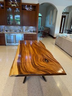 a large wooden table sitting in the middle of a living room next to a couch