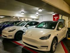 three electric cars are lined up in a parking garage