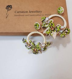 "Statement handcrafted beautiful off white-green with an accent of brown hoop earrings. These beaded petal and flower earrings are handmade of tiny seed beads put together into a floral shape using cabochons. These intricate earrings are one of the best creations of Carnation Jewellery. An ideal earring for the summers and ideal for bridesmaid. The earrings measure about approx.2.60\" long and 2.30\" wide Carnation jewellery is handmade & handcrafted in India. There may be a possibility of a Green Hoop Earrings For The Beach, Green Hoop Earrings For Beach, Green Spring Beach Jewelry, Handmade Green Beaded Hoop Earrings, Handmade White Beaded Earrings For Spring, Green Beaded Hoop Earrings For Summer, Summer Beaded Green Hoop Earrings, Green Hoop Earrings As Summer Gift, Green Hoop Earrings For Gifts