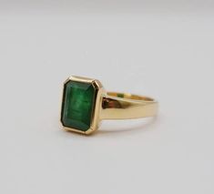 Formal Bezel-set Baguette-cut Emerald Ring, Formal Baguette Cut Emerald Ring With Bezel Setting, Classic Emerald Signet Ring With Bezel Setting, Classic Emerald Ring With Smooth Bezel For Anniversary, Timeless Bezel-set Emerald Cut Emerald Ring, Green 14k Gold Signet Ring With Bezel Setting, Yellow Gold Emerald Signet Ring With Bezel Setting, 14k Gold Ring With Bezel Setting And Emerald Cut, Emerald Cut Bezel Setting Jewelry For Formal Events