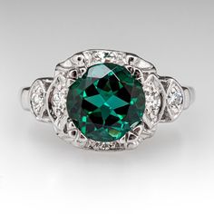 an emerald colored diamond surrounded by white diamonds