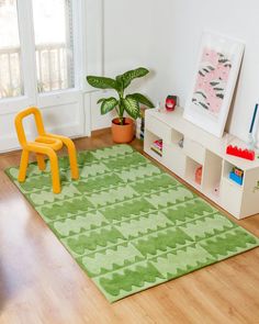 a child's play room with green rug and yellow chair