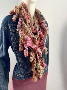 This Rosa scarf has the colors and textures of Fall.  It is a free-form crochet scarf made from various wool blends and synthetic yarns in a beautiful array of soft colors of pinks, beige, camel, greens, purples, rose, gold, and many more. There are lots of very soft hand-spun yarns in this scarf, making it ultra-soft.  There are various splits in the scarf pattern to allow you to pull ends through for more style possibilities.  The video shows how the random breaks in the pattern allow you to pull the scarf through for more styling possibilities.  It is about 72 inches long/ and varies between 3,5-4.5  inches wide (varies throughout the scarf) and can be used to create many different looks.   NOTE: The 2024 scarf collection celebrates remarkable women by naming each scarf after a specific Hand Knitted Multicolor Scarves For Fall, Pink Shawl For Fall, Bohemian Yarn Scarves For Fall, Bohemian Knitted Scarves For Fall, Pink Hand Knitted Scarves One Size, Fall Multicolor Crochet Scarf, Pink Bohemian Scarves For Fall, Pink Bohemian Scarf For Fall, Bohemian Knit Scarves For Fall