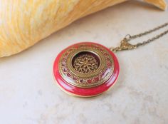 "Victorian style photo locket in a rich rose color has been layered with layers of bronze filigree detailed with intricate color inlaid in the filigree design on the locket. Each layer has been sealed with a clear resin so your locket will give you a lifetime of joy. Locket is 1 1/4\" in diameter and hangs from a bronze filigree connector with bronze plated chain. The chain fastens with a lobster clasp. Total pendant drop length including filigree connector is 2 1/4\" and is pictured with a 20\" Saint Helens, Photo Locket Necklace, Style Photo, Photo Locket, Filigree Design, Necklace Box, Skull And Crossbones, Small Photos, Clear Resin