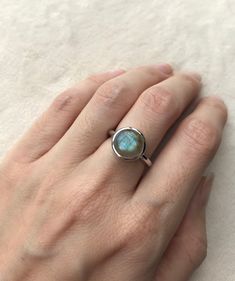 "A Boho Iridescent Round Smooth Genuine Natural Labradorite Sterling Silver Ring featuring a comfort fit band with a bezel around the stone. PLEASE NOTE Labradorite will vary in color as each gemstone is unique. This is a mesmerizing gemstone known for it's flash. Wrapped in a box ready for gift giving.(r-497) RING INFO ---------------- STERLING SILVER Stone 10MM (0.39inches) High Quality Sterling Silver 925 Tarnish Resistant *Model is wearing a size 5 *Follow us @belesasjewelry on Instagram for Bohemian Handmade Iridescent Rings, Adjustable Labradorite Rings For Anniversary, Adjustable Moonstone Ring For Everyday, Adjustable Everyday Moonstone Ring, Adjustable Round Midi Rings With Bezel Setting, Adjustable Midi Rings With Bezel Setting, Adjustable Stackable Round Moonstone Ring, Round Labradorite Anniversary Jewelry, Iridescent Gemstone Promise Ring