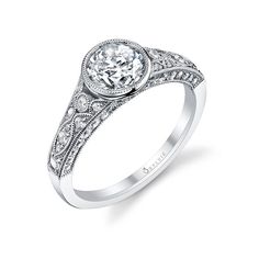 a white gold engagement ring with an oval diamond center and filigrees on the band