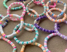 colorful bracelets are laid out on the floor for use in crafts or as decoration