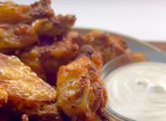 some fried food is on a plate with ranch dressing