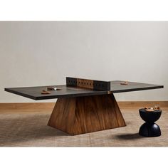 a ping pong table with two pieces of wood on it and a black vase in the foreground