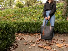 The Grand Bellfield Tote. Fits it all! This leather tote bag is meticulously crafted and known for its distinctive strap design. The interior of each tote is as detailed as the exterior, featuring two spacious pockets as well as an interior D-ring for your convenience. The Bellfield Tote’s classic look and timeless design allows you to dress each bag up or down, while still providing you with ample space, strength, and functionality for your favorite this and that.