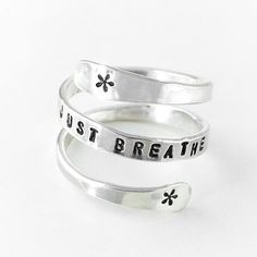 This ring is so comfortable to wear! Created from sterling silver wire, this ring is hand-flattened and hand-stamped with the words JUST BREATHE and some wispy swirls on either side, and gently wraps around your finger as a constant reminder to exhale. This ring can be personalized with Inspirational Adjustable Silver Rings, Inspirational Adjustable Sterling Silver Rings, Adjustable Inspirational Sterling Silver Rings, Customizable Adjustable Sterling Silver Engraved Ring, Adjustable Sterling Silver Stackable Rings, Adjustable Customizable Engraved Sterling Silver Ring, Meaningful Adjustable Silver Stackable Rings, Adjustable Nickel Free Sterling Silver Engraved Ring, Adjustable Hypoallergenic Silver Engraved Ring