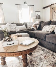 a living room filled with furniture and pillows on top of a rug next to a coffee table