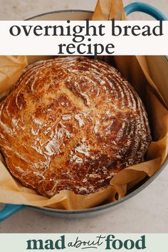 a loaf of bread sitting in a blue pot on top of a white countertop