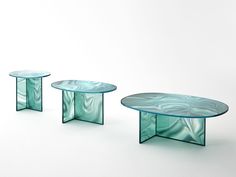 three glass tables sitting next to each other