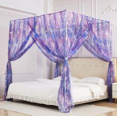 a bed with purple drapes and lights on it