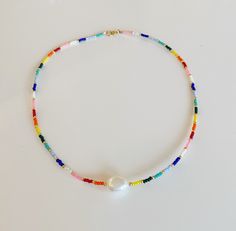 Rainbow and Pearl necklace/Beaded Rainbow Pearl necklace/Colourful Beaded chocker necklace/Colourful bead and pearl Add a bohochic vibe to your outfit with this colourful beaded chocker necklace. Layer it up with other necklaces for a rich bohemian look or wear it alone for a clean and chic style. SPECIFICATIONS Materials: * Seedbead rainbow mix and a freshwaterpearl in the front. * Goldfilled clasp and goldplated extenderchain. ❤Handmade with love by me in my jewelrystudio in Oslo, Norway. SIZE Rainbow Beaded Necklaces For Summer Festivals, Summer Festival Rainbow Beaded Necklaces, Adjustable Bohemian Pearl Necklace With Tiny Beads, Bohemian Pearl Choker Necklace, Bohemian Pearl Beaded Necklaces With Tiny Beads, Festival Pearl Beaded Necklaces, Adjustable Multicolor Pearl Necklace For Summer, Bohemian Pearl Necklace With Tiny Beads For Summer, Bohemian Pearl Choker