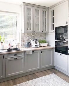 a kitchen with gray cabinets and white appliances