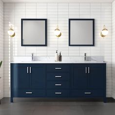 two sinks and mirrors in a bathroom with white tiles on the walls, blue cabinets