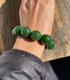 18mm A Grade Canadian Nephrite Jade Beads 12 beads on an elastic cord, measures 7.5." Hand-strung Jade Beads For Jewelry Making, Handmade Round Jade Beads, Jade Bead Bracelet, Hand-strung Green Jade Beaded Bracelets, Spiritual Polished Jade Beads, A Grade, Jade Charm, Hand-strung Green Jade Beads, Nephrite Jade