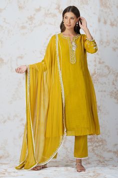 Mustard yellow floral embroidered A line kurta in cutdana and sequin work. Paired with lace hem pant and dupatta. Comes with rayon slip.
Component: 4
Pattern: Embroidered
Type Of Work: Zardozi work, Cutdana work, Bead work, Sequins
Neckline: Round notched
Sleeve Type: Three quarter
Fabric: Chanderi 40grm, Georgette, Glace Cotton, Rayon
Color: Yellow
Other Details: 
Embroidered dupatta
Bead tassel sleeve hem
Occasion: Sangeet - Aza Fashions Kurta Style, A Line Kurta, Smart Outfit, How To Hem Pants, Pernia Pop Up Shop, Lace Hem, Yellow Fabric, Kurta Set, Vintage Summer