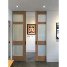 an open door with frosted glass panels on the inside and outside of it, leading into a hallway