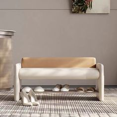 a white bench sitting on top of a tiled floor next to a vase and potted plant