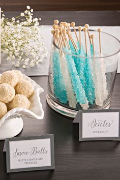 there is a bowl full of candy and place cards on the table with sweets in it