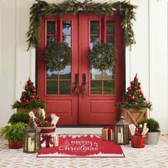 red front door decorated for christmas with wreaths and decorations